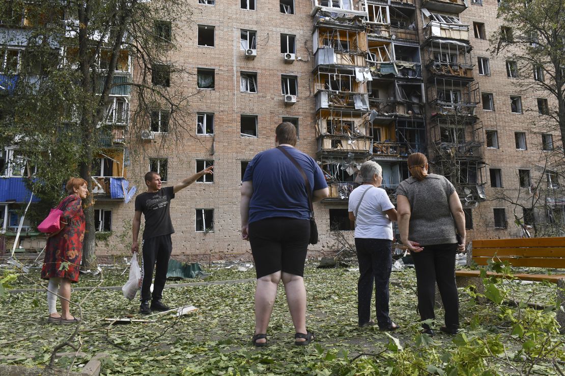 Residents of an apartment building damaged after shelling by the Ukrainian side stand near the building in Kursk, Russia, on Sunday. (AP Photo)