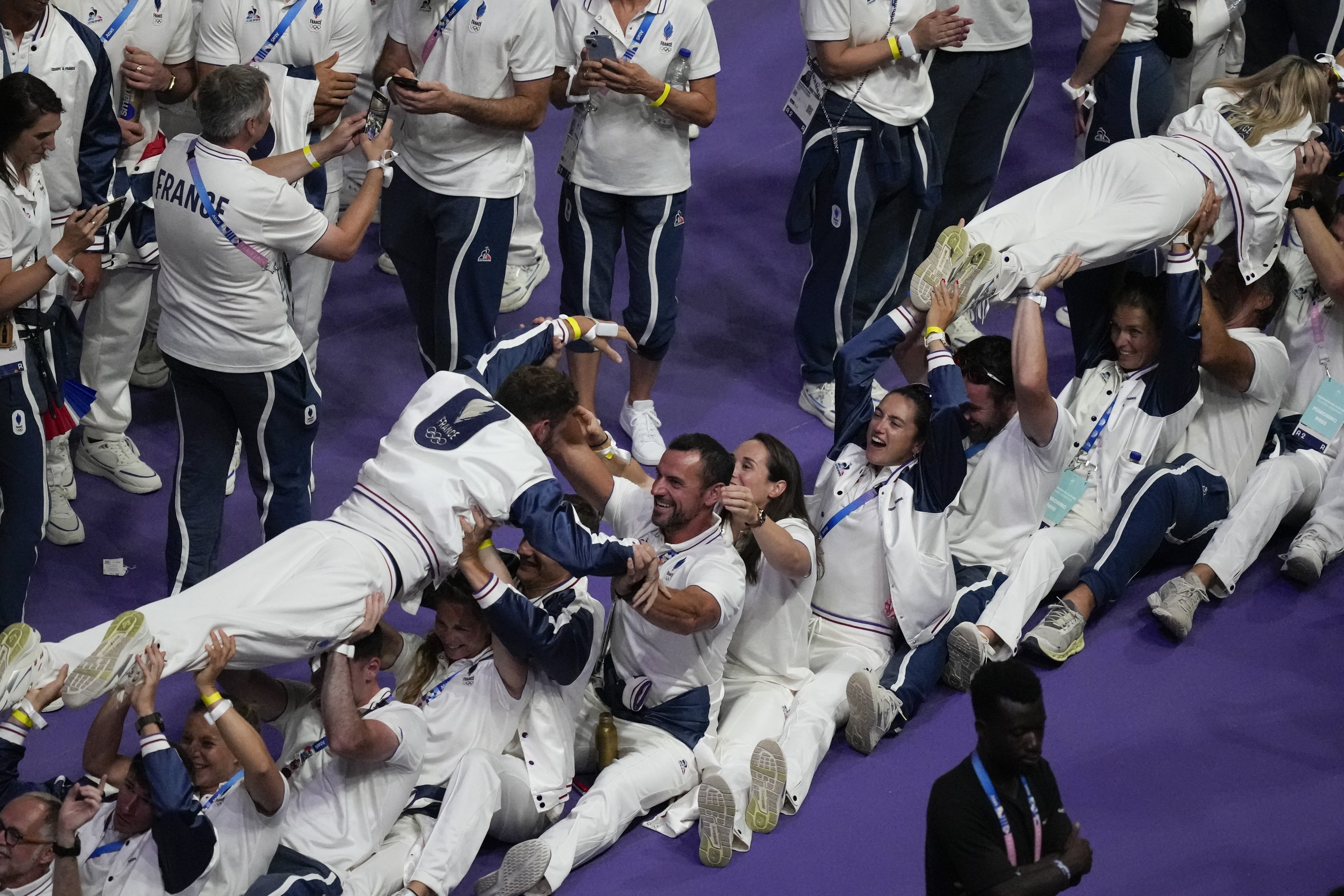 Athletes from the French team do a little crowd surfing.