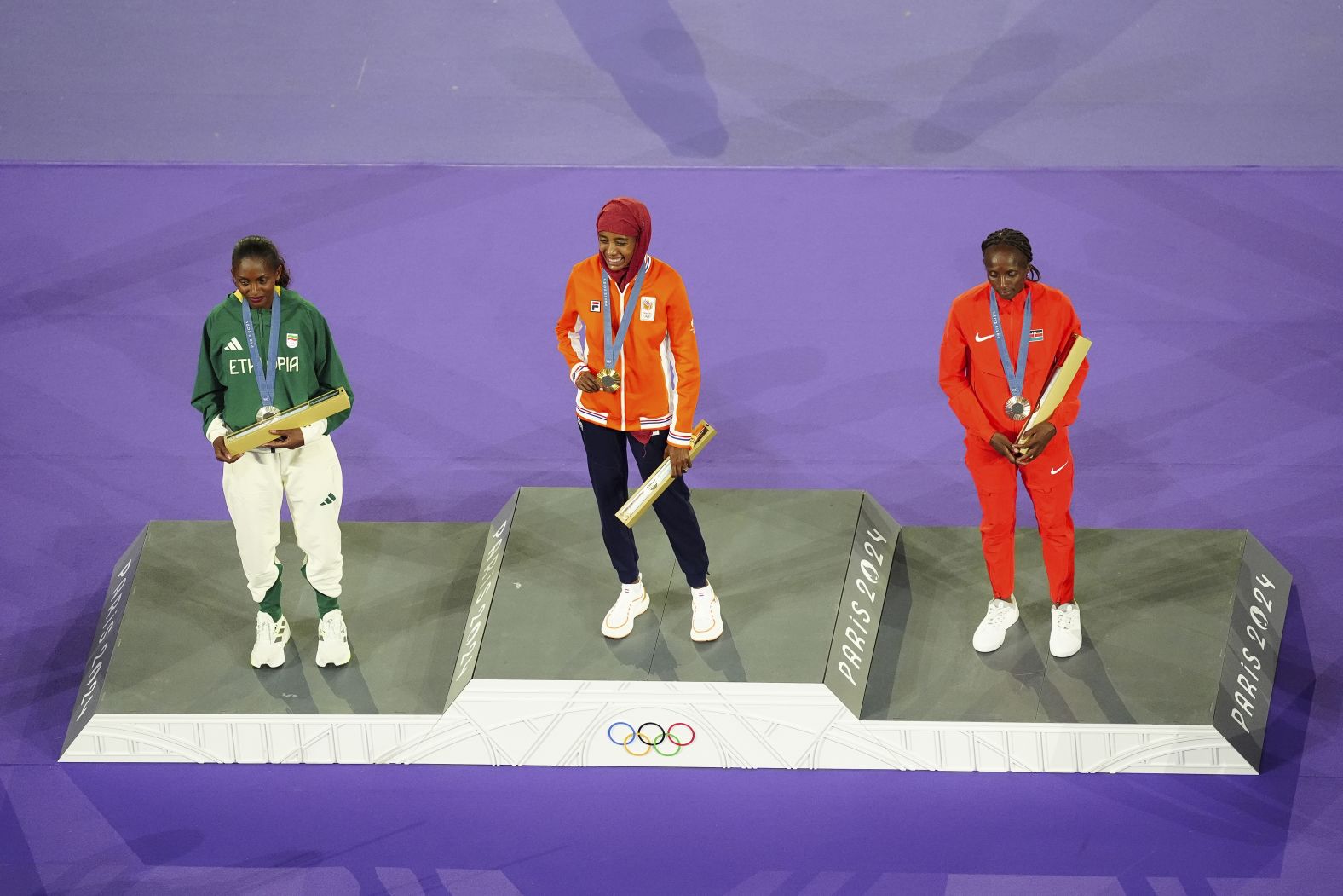 From left, Ethiopia's Tigst Assefa, the Netherlands' Sifan Hassan and Kenya's Hellen Obiri stand for a <a href="https://www.cnn.com/sport/live-news/paris-olympics-news-closing-ceremony#h_6b323aea3996098d90e4a4927e9fb92c">medal ceremony</a> held during the closing ceremony. Hassan won gold in the marathon earlier in the day.