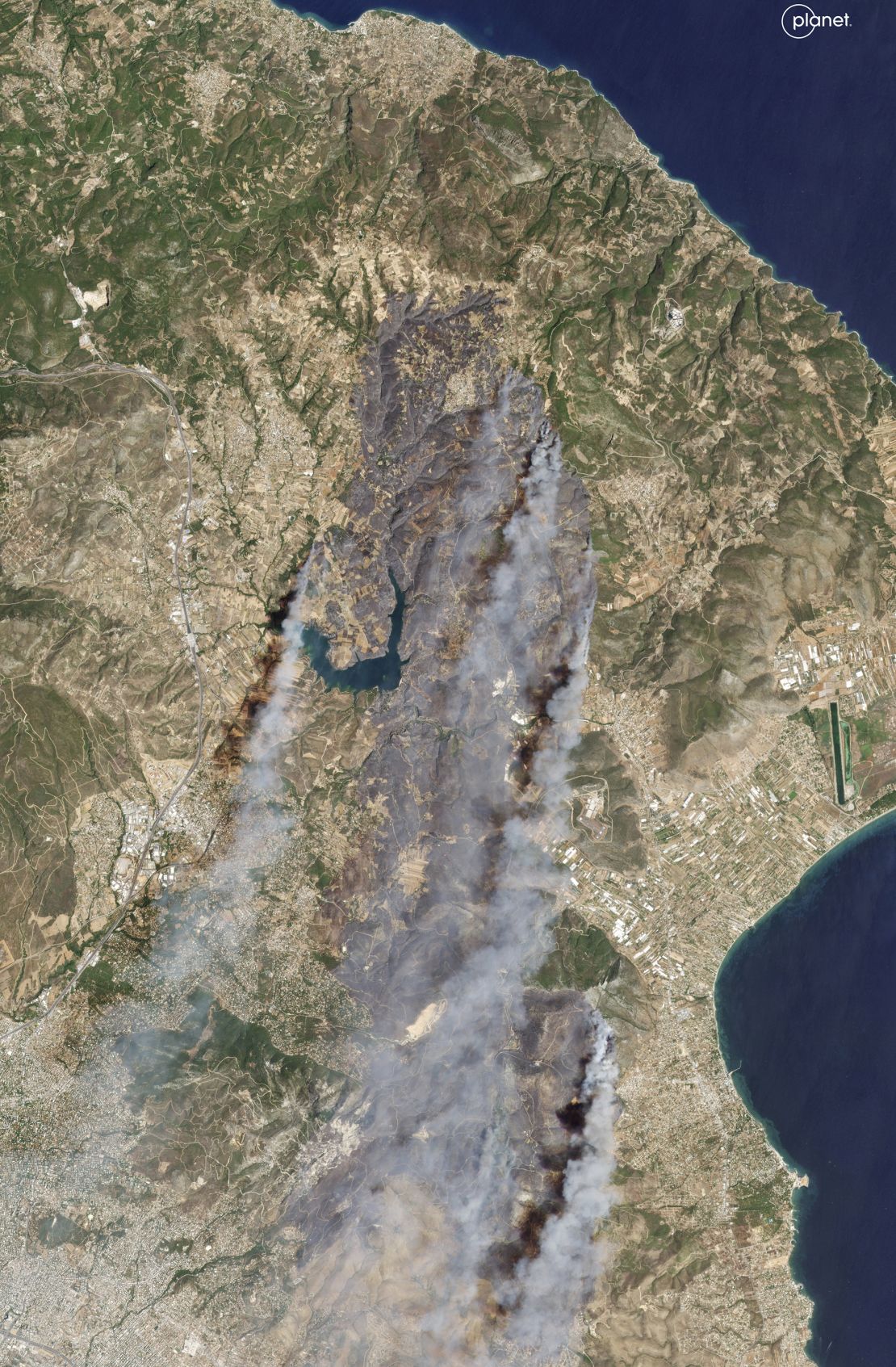 Esta imagem de satélite mostra a fumaça subindo dos incêndios florestais no leste da Ática, ao norte de Atenas, que se espalharam pelos subúrbios do norte e causaram uma série de evacuações, na segunda-feira.