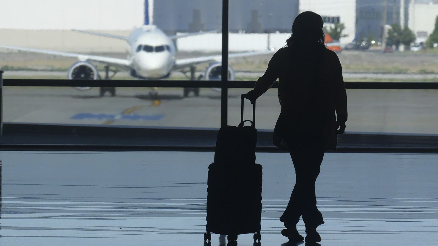 A holiday traveler looks out at a airplane at Salt Lake City International Airport over the July 4 holiday weekend.