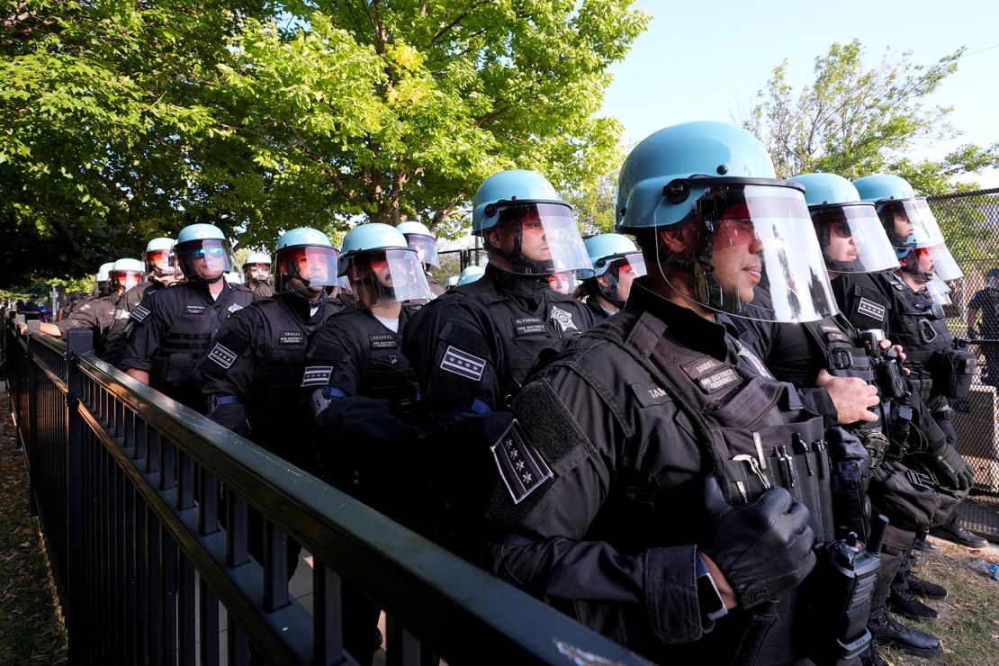 Police line up after a piece of fence was knocked down by protesters surrounding the United Center at the Democratic National Convention Monday, Aug. 19, 2024, in Chicago.