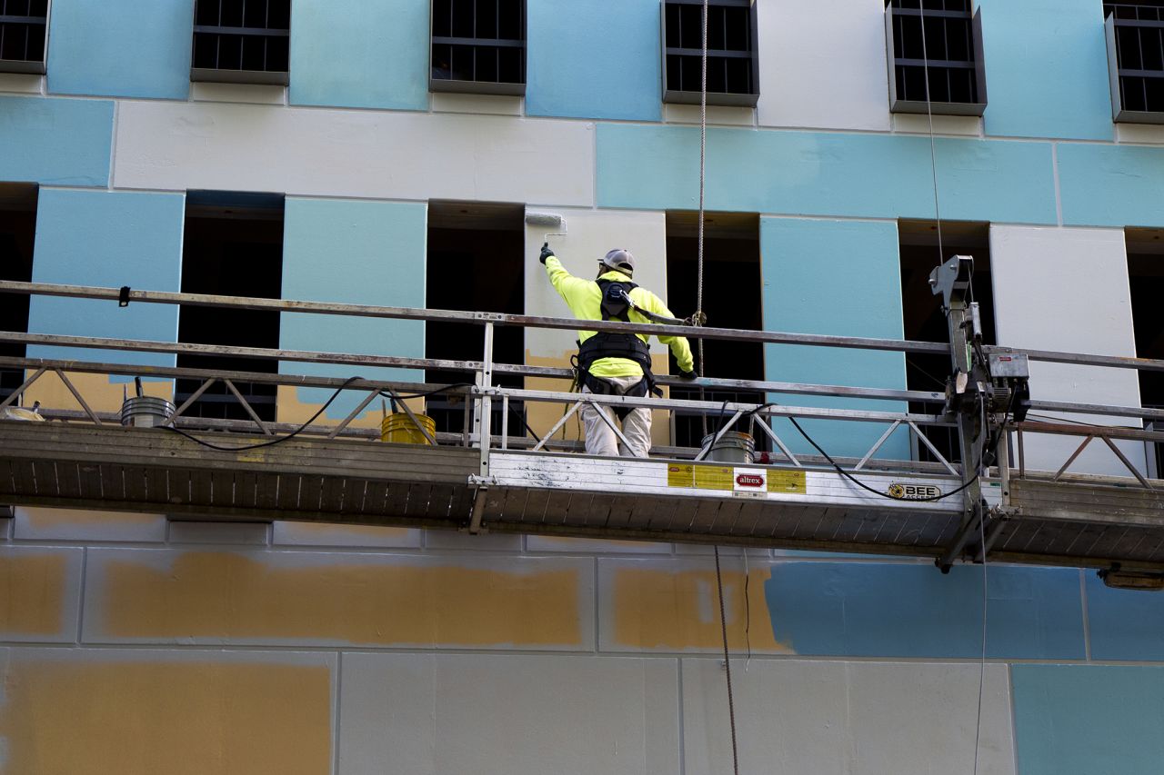 A worker paints the side of a building on August 26 in Portland, Oregon.