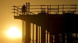 Construction workers start their day as the sun rises on the new Republic Airlines headquarters building in Carmel, Ind., Tuesday, Aug. 27, 2024. (AP Photo/Michael Conroy)