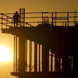 Construction workers start their day as the sun rises on the new Republic Airlines headquarters building in Carmel, Ind., Tuesday, Aug. 27, 2024. (AP Photo/Michael Conroy)