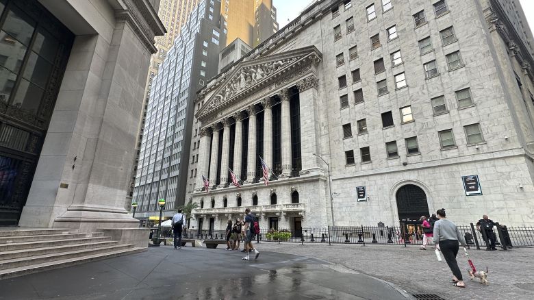 People pass the New York Stock Exchange on August 28.