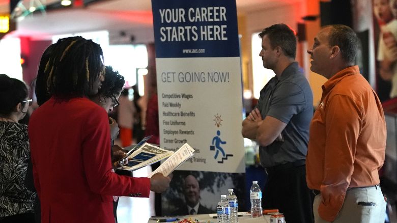 Jason Kolb, with Allied Universal Services, right, front, talks with prospective job applicants at a job fair on August 29, 2024, in Sunrise, Florida.