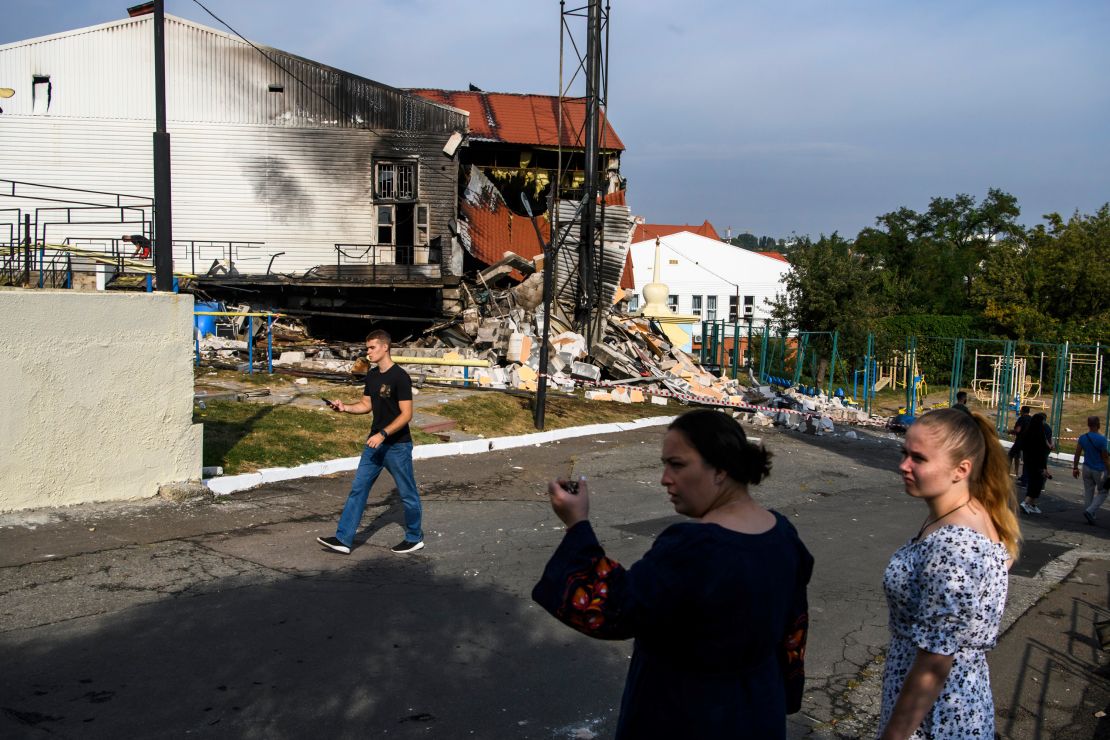People stand near the sports complex of a university after Russian missile attacks in Kyiv, Ukraine, on September 2.