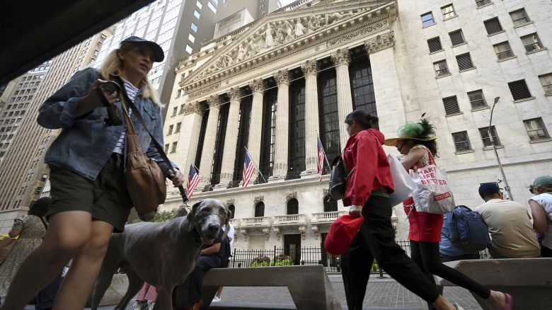 People walk past the New York Stock Exchange along Broad Street.