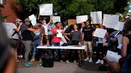 Resident Jaun Carlos Jimenez, center left, listens as Jeraldine Mazo, center right, speaks during a rally staged by the East Colfax Community Collective to address chronic problems in the apartment buildings occupied by people displaced from their home countries in central and South America Tuesday, Sept. 3, 2024, in Aurora, Colo.