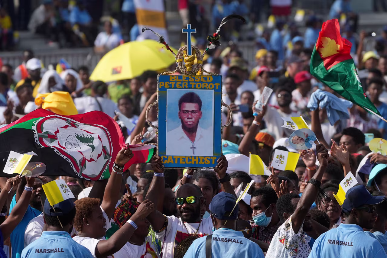 Attendees hoist a picture of blessed Peter To Rot during a meeting between Pope Francis and young people at the Sir John Guise stadium in Port Moresby, Papua New Guinea, on September 9, 2024.