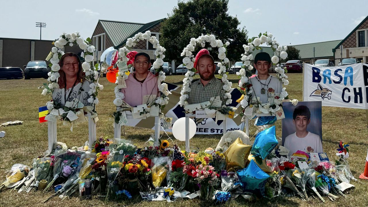 A poster with images of shooting victims from left, Cristina Irimie, Mason Schermerhorn, Richard Aspinwall and Christian Angulo is displayed at a memorial outside Apalachee High School, Tuesday, Sept. 10, 2024, in Winder, Ga.  (AP Photo/Charlotte Kramon)