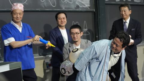 A team of researchers perform a demonstration during a performance showing that many mammals are capable of breathing through their anus while accepting the 2024 Ig Nobel prize in physiology.