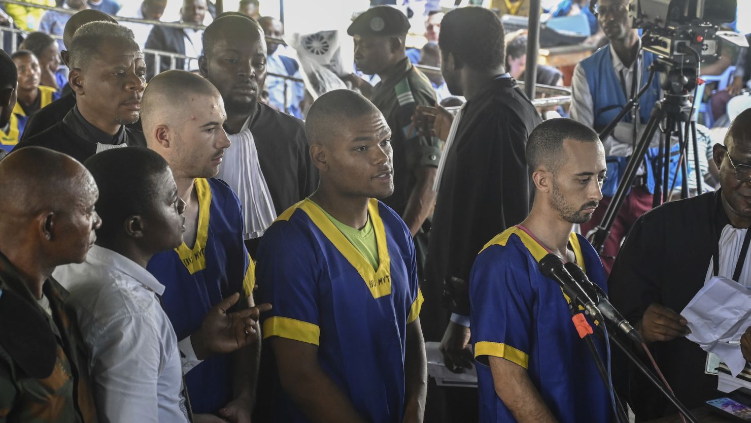 From left: Tyler Thompson Jr, Marcel Malanga and Benjamin Reuben Zalman-Polun, all American citizens, face the court in Kinshasa with 52 other defendants on June 7, 2024.