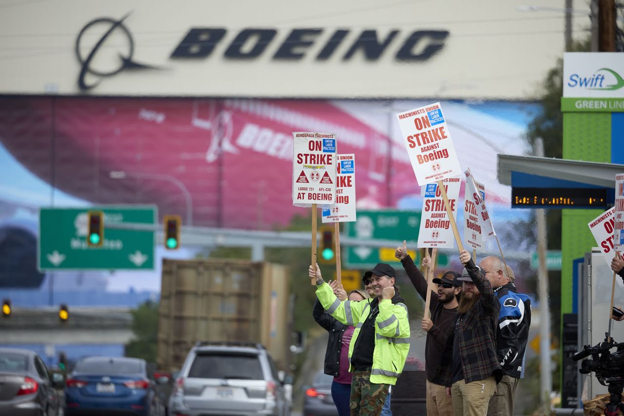 Boeing Machinists Union members wave to traffic while on the picket line at the Everett plant, on September 13 in Everett, Washington.