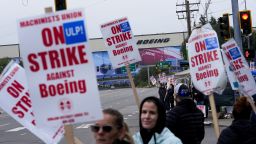 Boeing workers wave picket signs as they strike on September 15, near the company's factory in Everett, Washington.