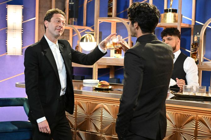 Actors Ebon Moss-Bachrach, left, and Taylor Zakhar Perez share a toast on camera before presenting an award.