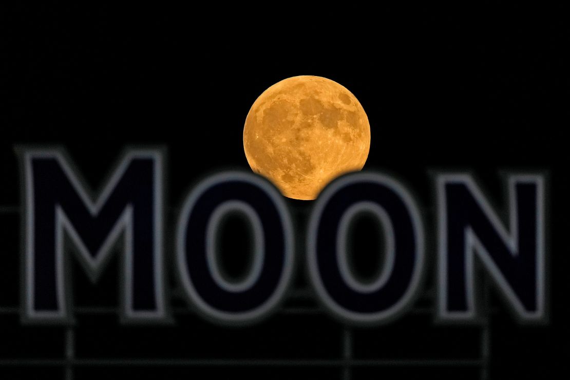 A full moon rises over a beer sign in the outfield of Kauffman Stadium during a baseball game between the Kansas City Royals and Detroit Tigers on Tuesday.