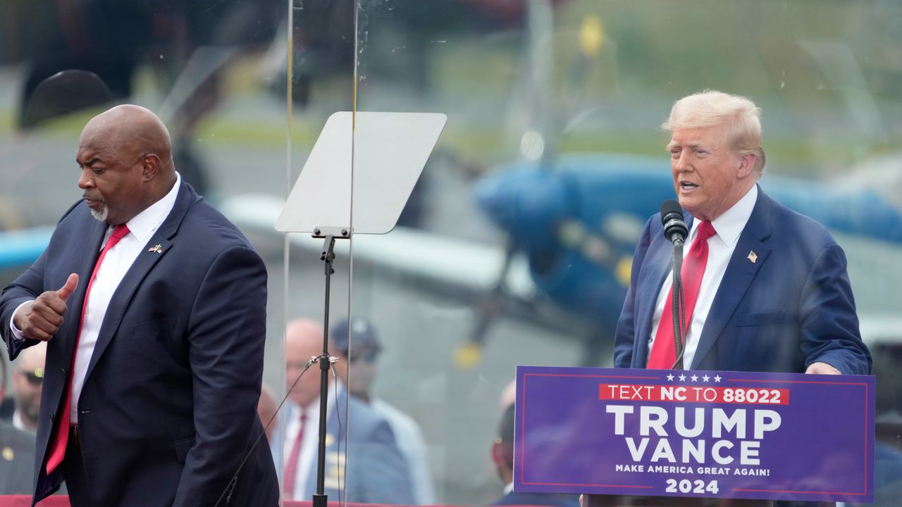 North Carolina Lieutenant Governor Mark Robinson (left) walks past former President Donald Trump (right) after being introduced at a Trump campaign rally in Asheboro, North Carolina, on August 21, 2024.