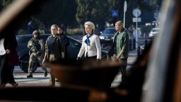 President of the European Commission Ursula von der Leyen, center, is framed by a wreck of the Russian military on display in the square on her way to visit a memorial wall commemorating the fallen Ukrainian soldiers in the war with Russia, in Kyiv, Ukraine, Friday, Sept. 20, 2024. (Christoph Soeder, Pool via AP)