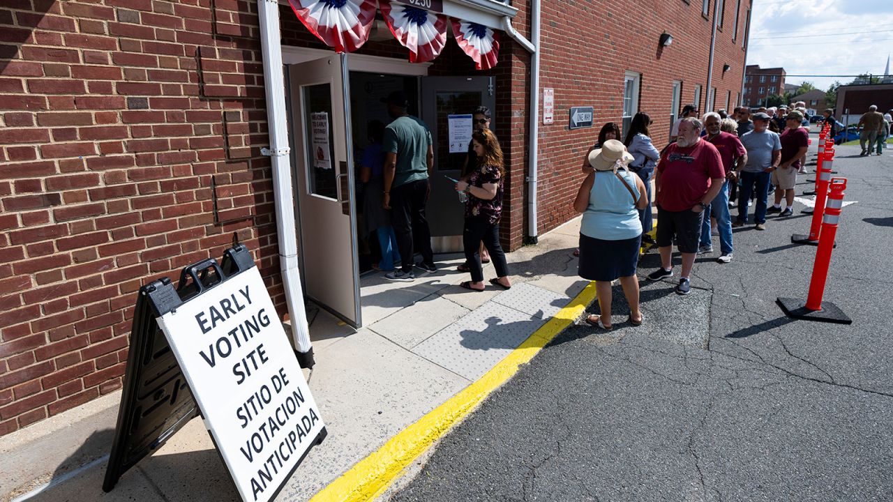 Voters stand in line to cast their ballots on the first day of early voting in Virginia at the Prince William County Office of Elections in Manassas, Virginia, on Friday, September 20.