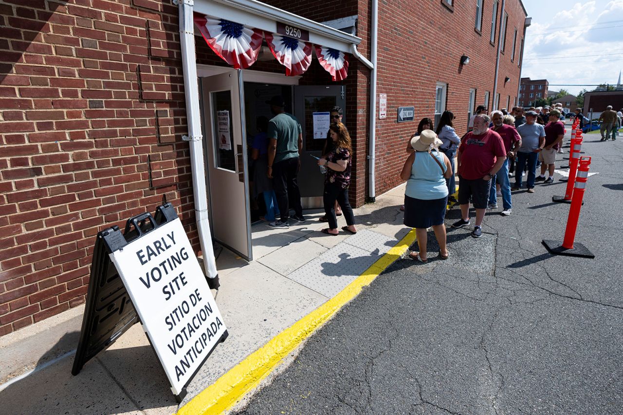 Voters stand in line to cast their ballots on the first day of early voting in Virginia at the Prince William County Office of Elections in Manassas, Virginia, on Friday, September 20.