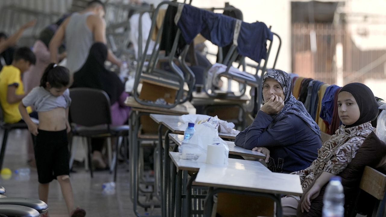 Displaced women and children sit in a classroom in Beirut being used as a shelter after fleeing the Israeli airstrikes in the south, on September 26.