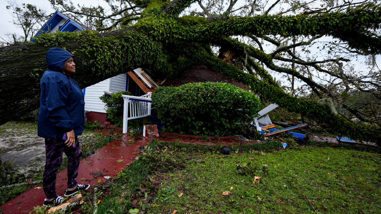 Ronda Bell looks at the damage after a tree fell on her home in Valdosta, Georgia, on Friday.