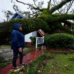 Ronda Bell looks on after an Oak tree landed on her 100-year-old home after Hurricane Helene moved through, Friday, Sept. 27, 2024, in Valdosta, Ga.