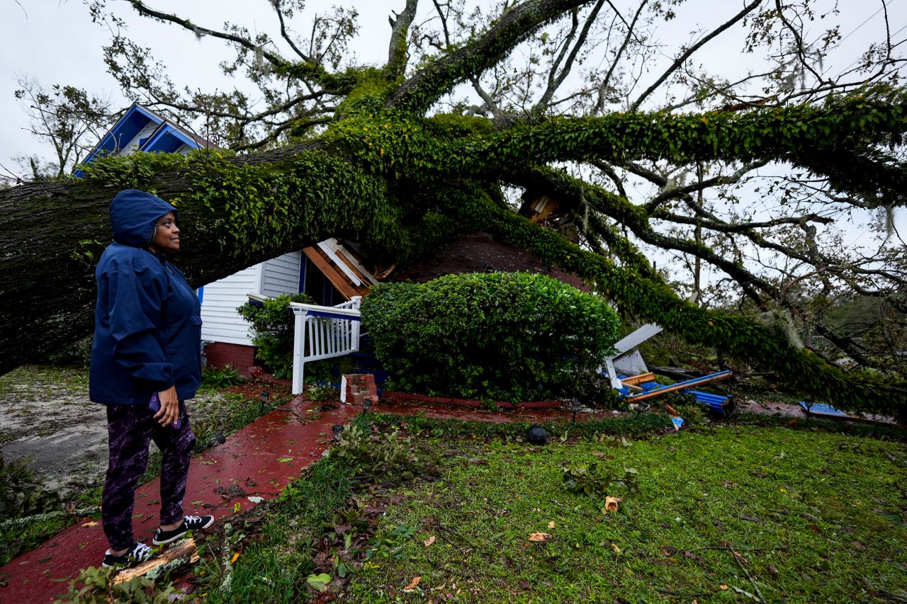 Ronda Bell looks at the damage after a tree fell on her home in Valdosta, Georgia, on Friday.