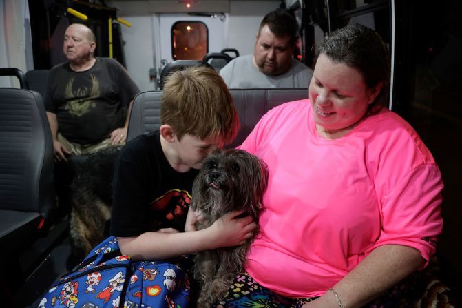 Sarah Cribbins and her son, Michael, cuddle their dog after being rescued from floodwaters in Crystal River, Florida, on Friday.