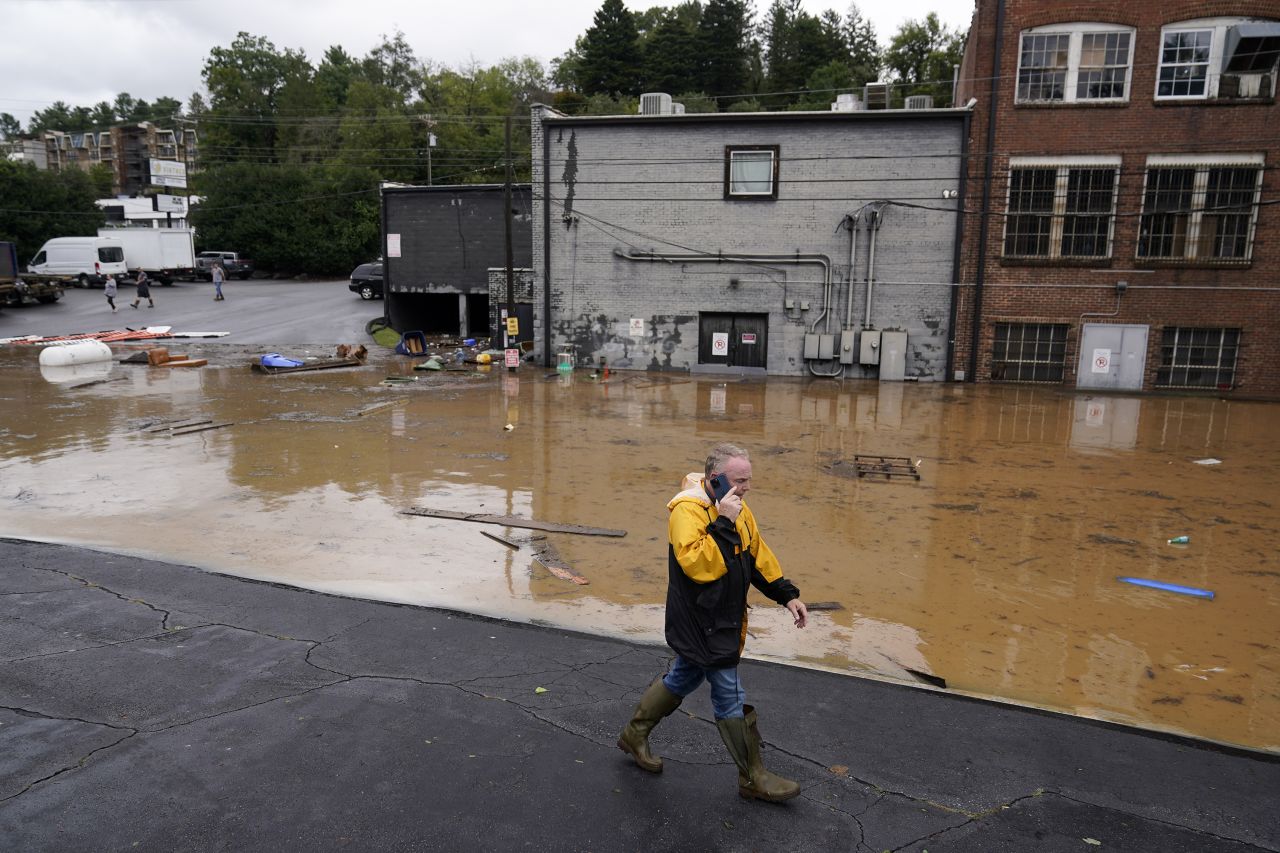 A man walks by a flooded area near the Swannanoa River in Asheville, North Carolina, on September 27.