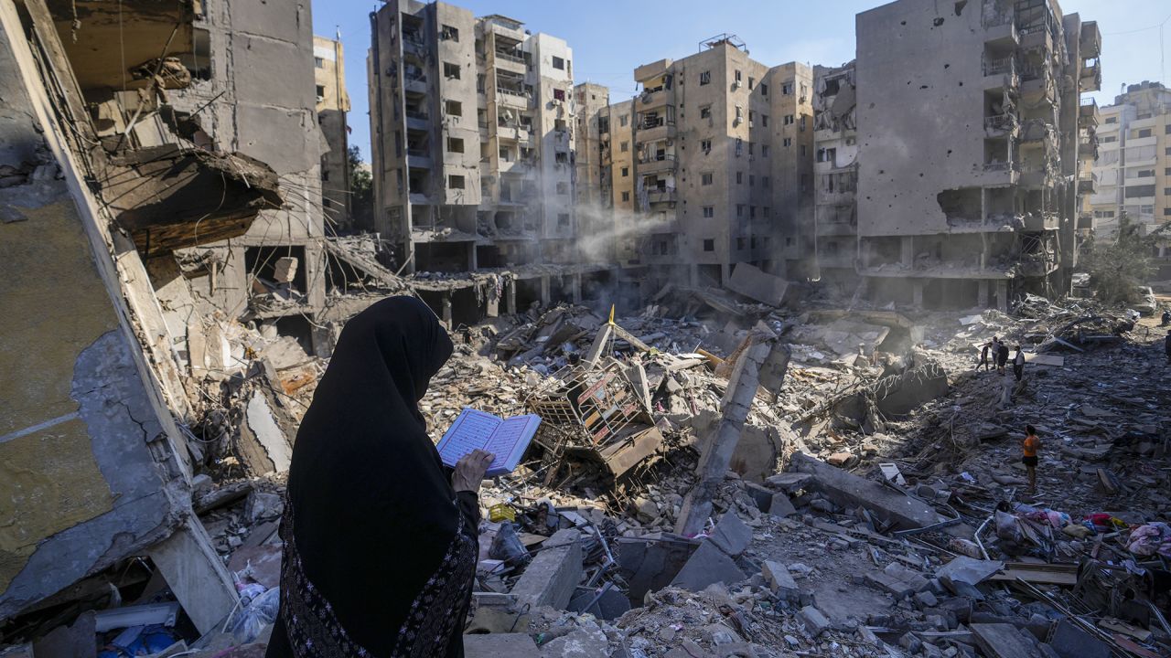 A woman reads the Quran at the site of the assassination of Hezbollah leader Hassan Nasrallah in Beirut's southern suburbs, Lebanon, on Sunday.