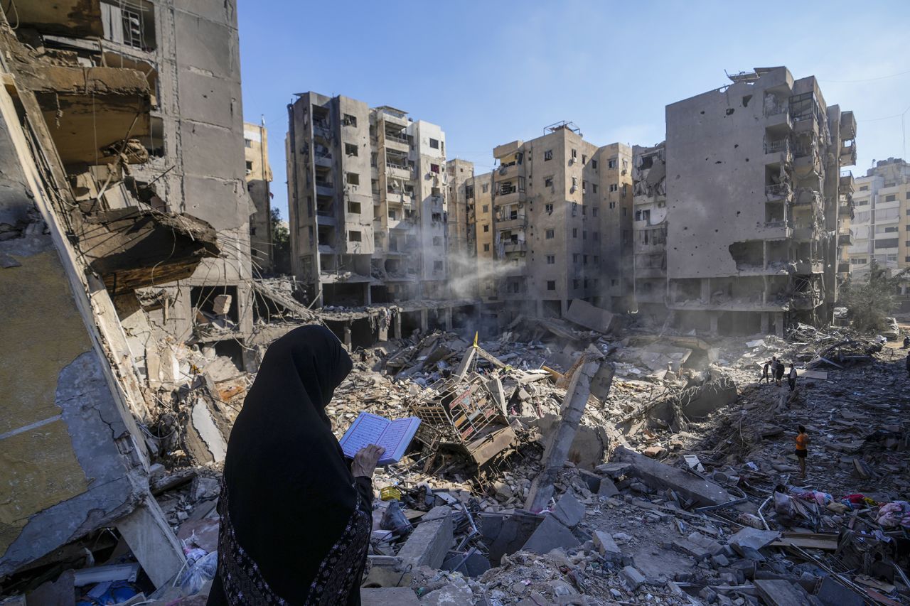 A woman reads the Quran at the site of the assassination of Hezbollah leader Hassan Nasrallah in Beirut's southern suburbs, Lebanon, on Sunday.