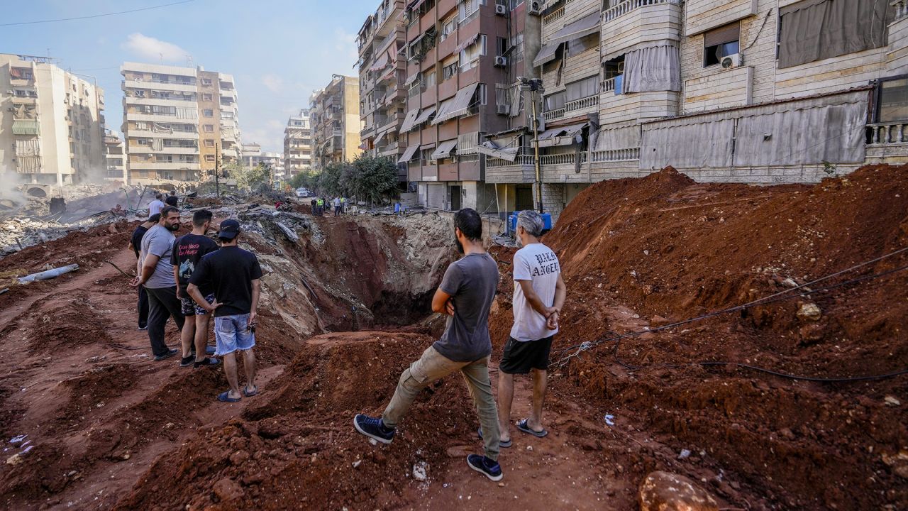 People gather at the site of the assassination of Hezbollah leader Hassan Nasrallah in Beirut's southern suburbs, Lebanon, on Sunday.