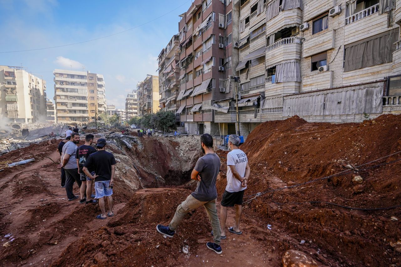 People gather at the site of the assassination of Hezbollah leader Hassan Nasrallah in Beirut's southern suburbs, Lebanon, on Sunday.