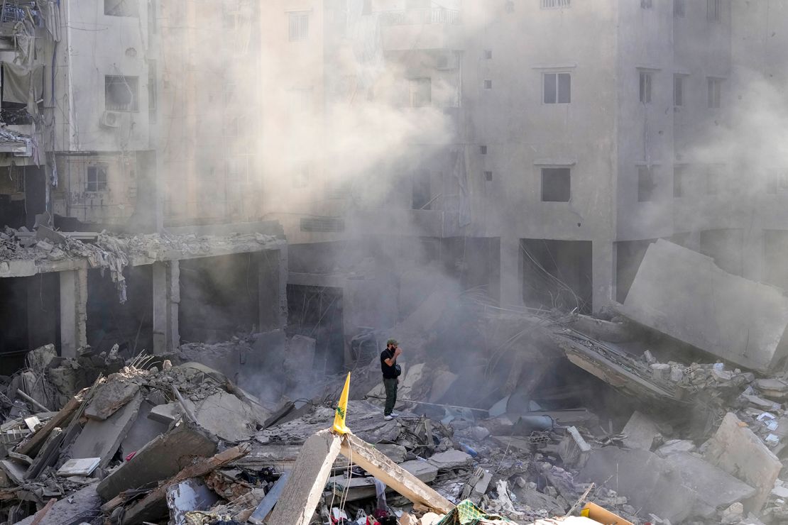 a man stands on the rubble of buildings near the site of the assassination of hezbollah leader hassan nasrallah in beirut's southern suburbs, on september 29, 2024.