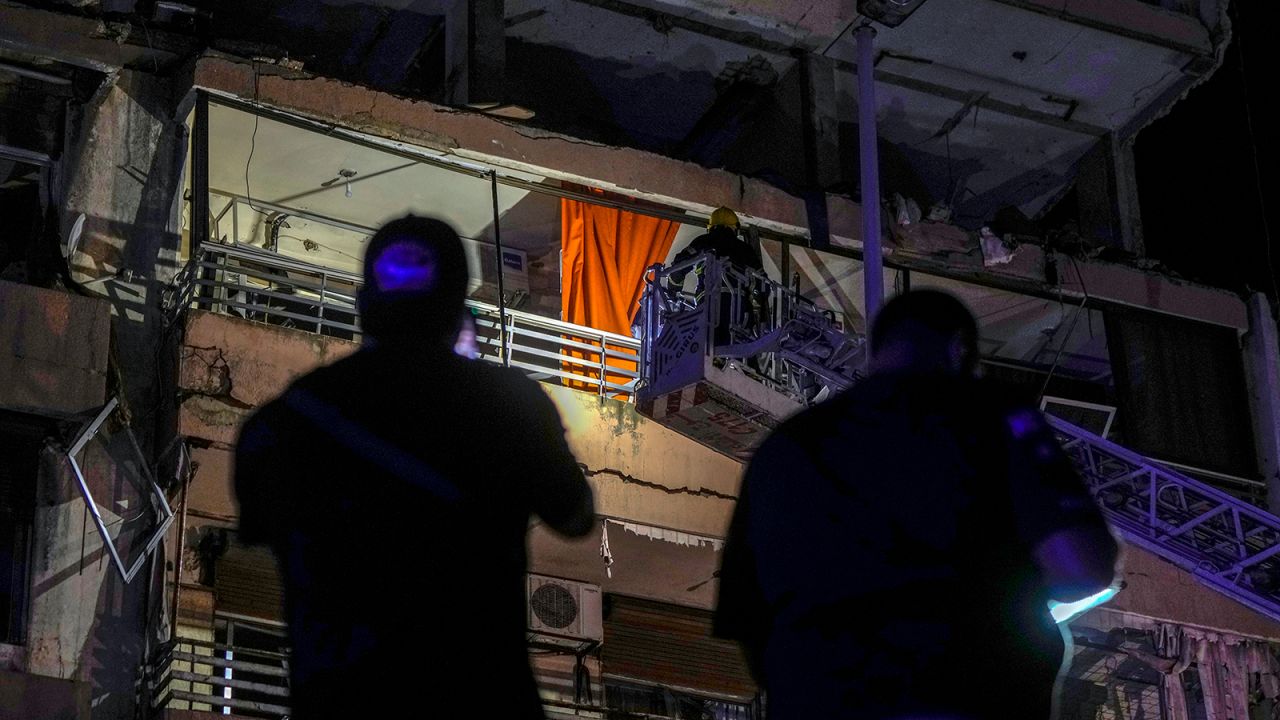 A fire engine ladder extends up a building that was hit in an airstrike, in central Beirut, Lebanon, early Monday.