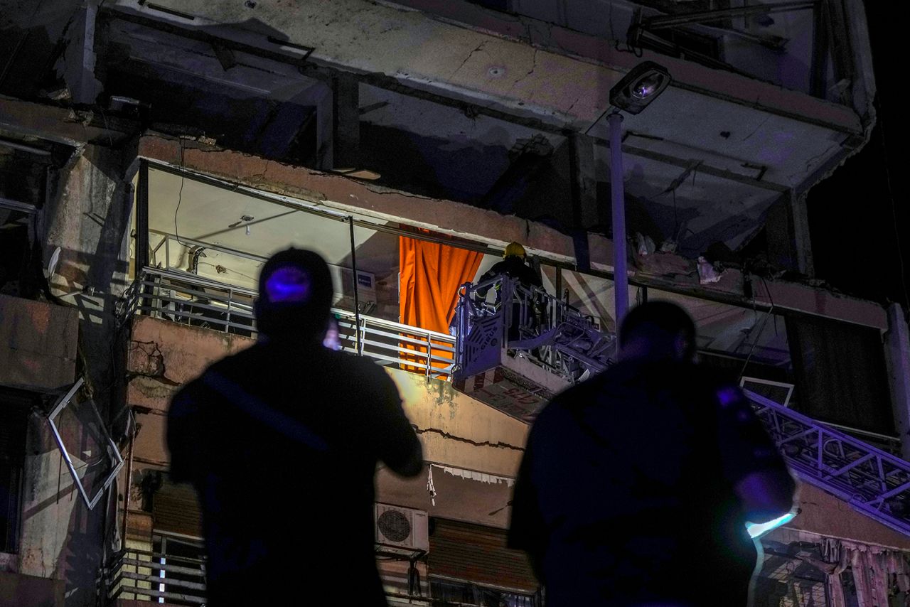 A fire engine ladder extends up a building that was hit in an airstrike, in central Beirut, Lebanon, early Monday.