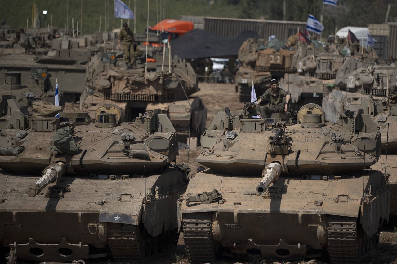 An Israeli soldier sits on the top of a tank, in northern Israel, on September 30.