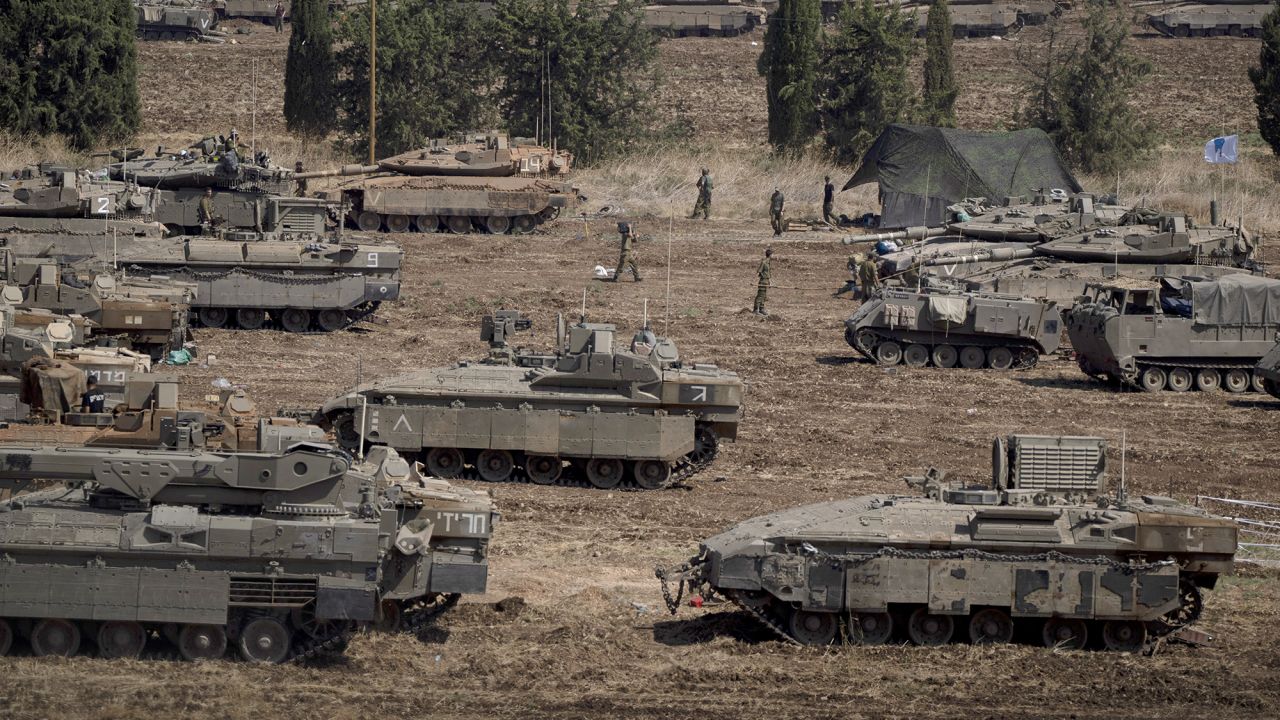 Israeli soldiers work on tanks and armoured personnel carriers in northern Israel, on September 30.