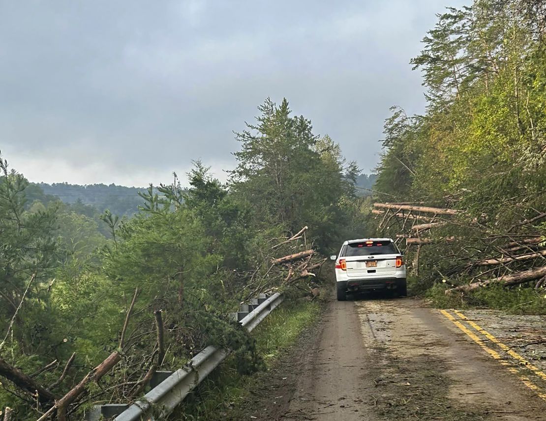 Rescue workers from Pamlico County navigate Saturday through downed trees on a road in the area of Chimney Rock, North Carolina.