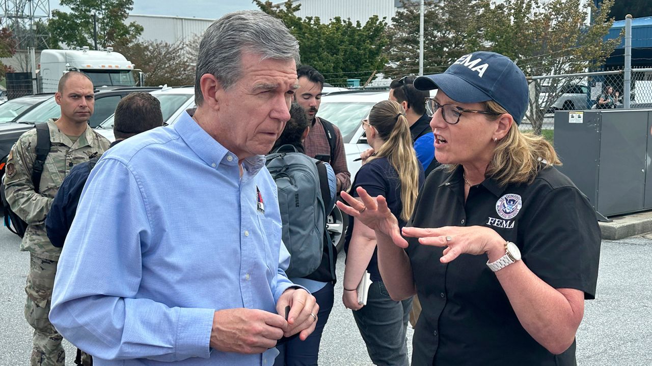 North Carolina Gov. Roy Cooper speaks with FEMA Administrator Deanne Criswell at the Asheville Regional Airport in Fletcher, North Carolina, on September 30.