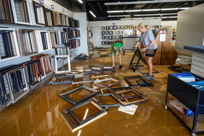 Linda Bandy, left, and Carissa Sheehan clean up inside the International Moulding frame shop in Morganton, North Carolina, on Monday.