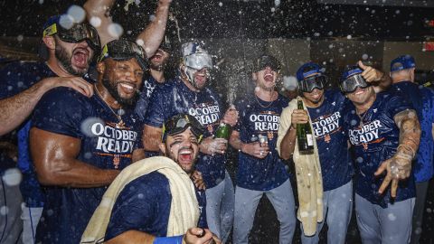 The New York Mets celebrate in the locker room after clinching a playoff berth with their come-from-behind victory in Game 1 of the doubleheader against the Atlanta Braves.