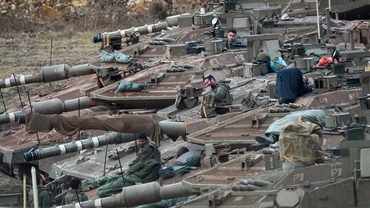 Israeli soldiers work on tanks in a staging area in northern Israel near the Israel-Lebanon border, on Tuesday.