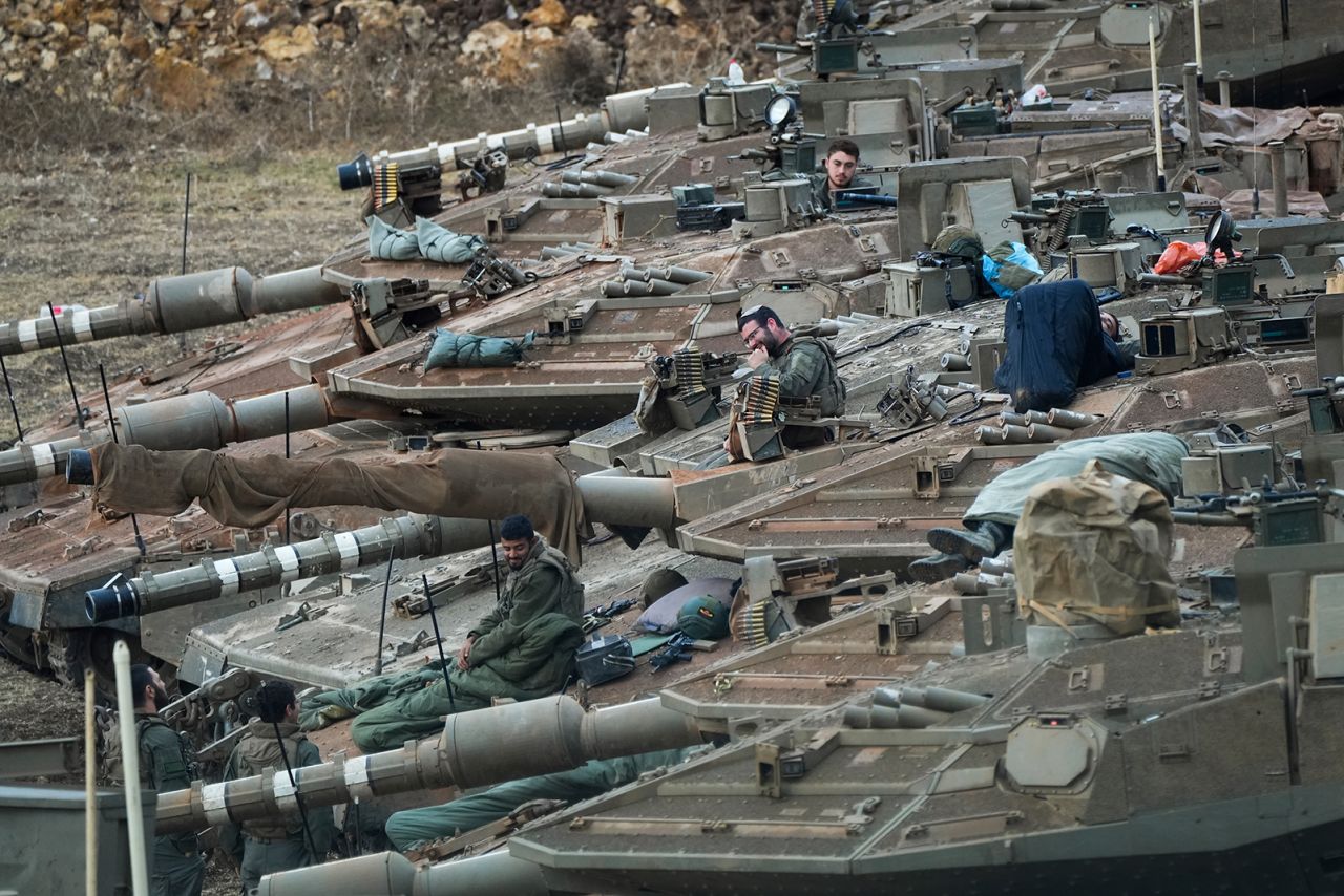 Israeli soldiers work on tanks in a staging area in northern Israel near the Israel-Lebanon border, on Tuesday.