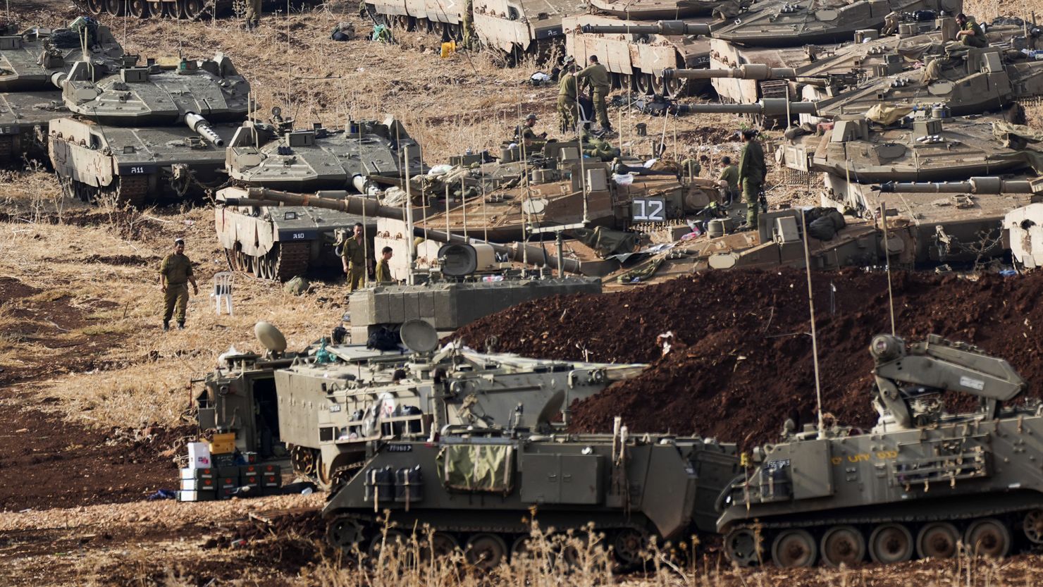 Israeli soldiers work on tanks at a staging area in northern Israel near the Israel-Lebanon border, Tuesday, Oct. 1, 2024.