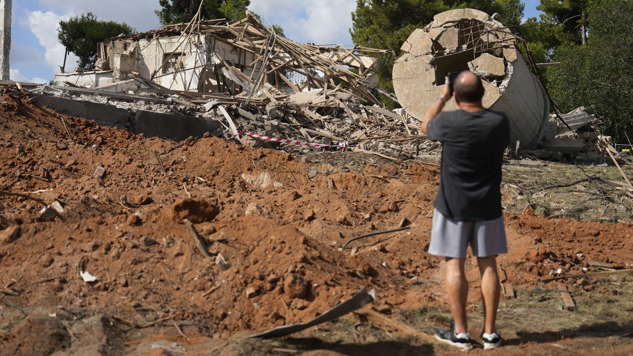 A man takes photos of a destroyed building in Hod Hasharon, Israel, on October 2.