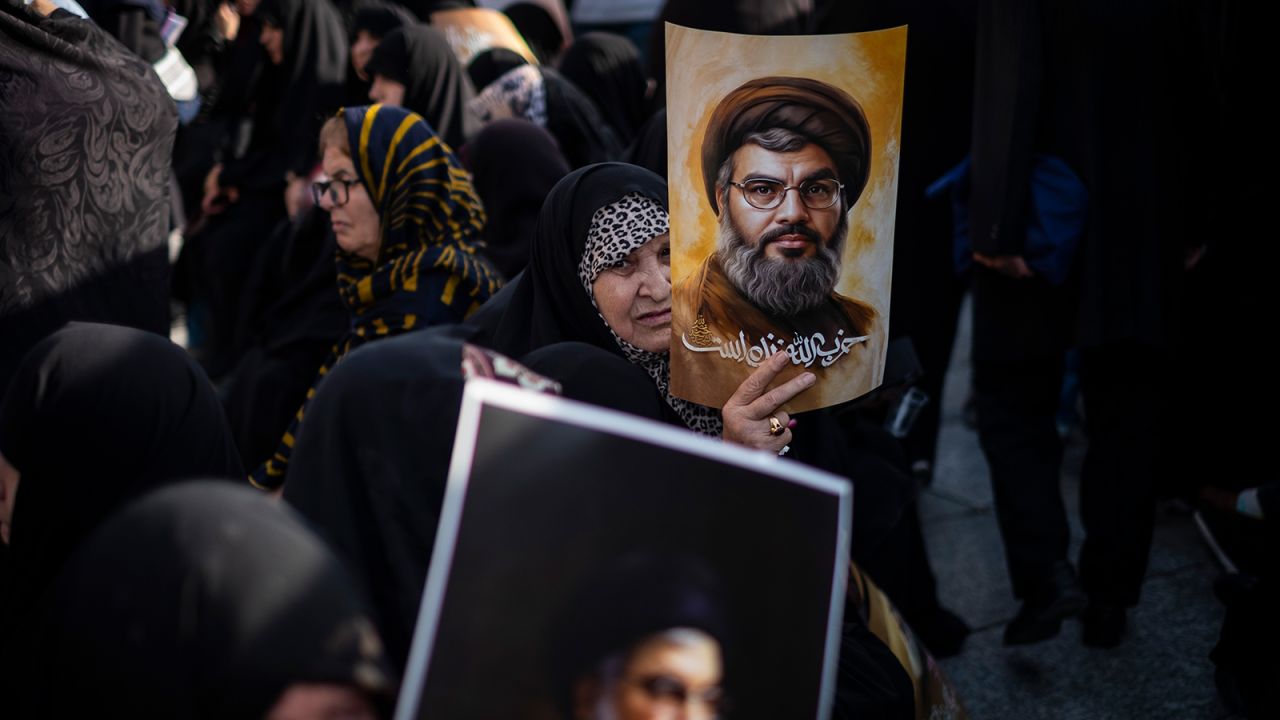 Veiled Iranian women hold portraits of Hezbollah leader Hassan Nasrallah during a memorial for Nasrallah and IRGC General Abbas Nilforoushan in Tehran, Iran, on October 2.